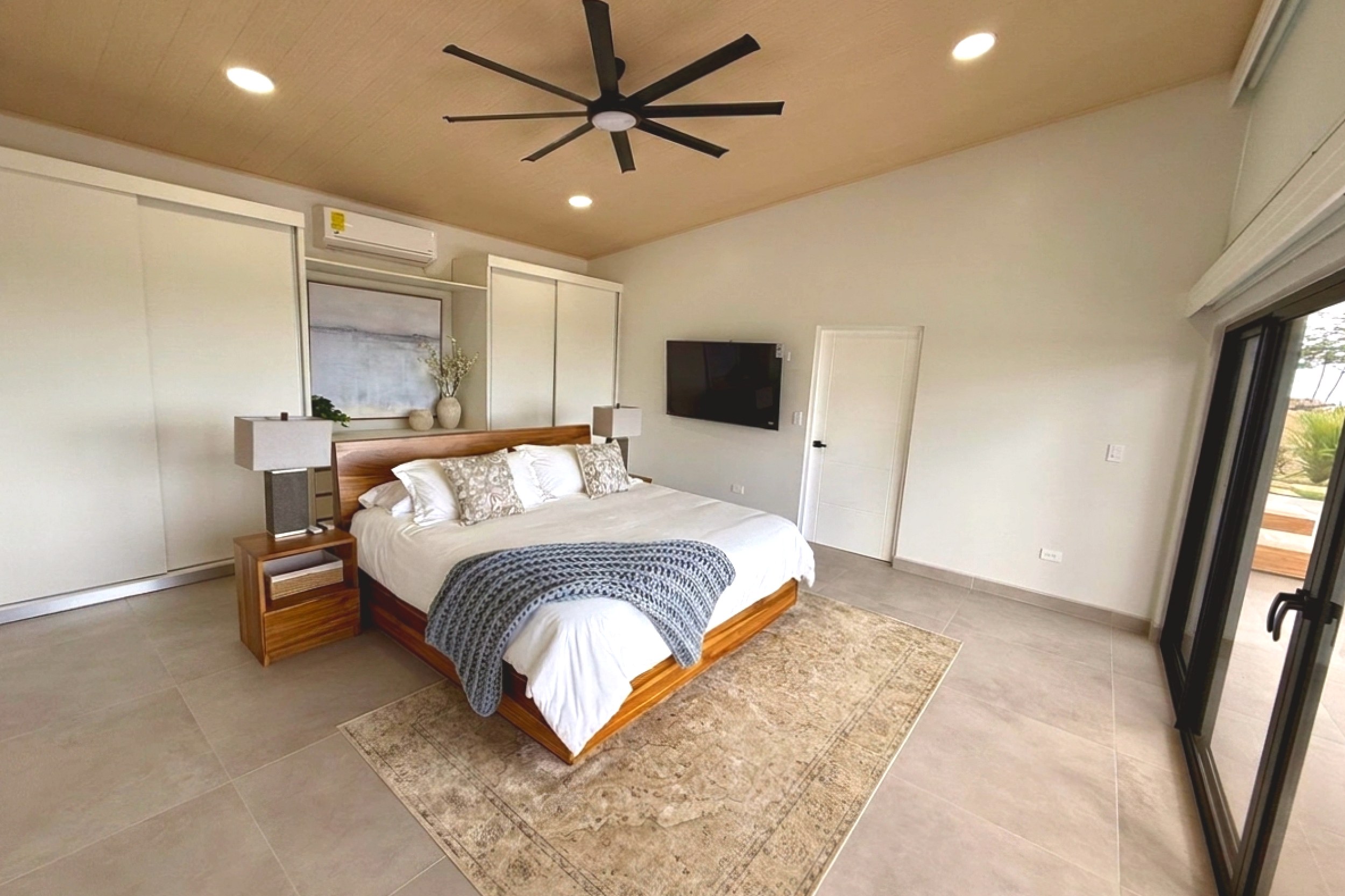 Modern Luxury 4-Bedroom Home main guest bedroom with bed and ceiling fan in Chontales, Costa Rica