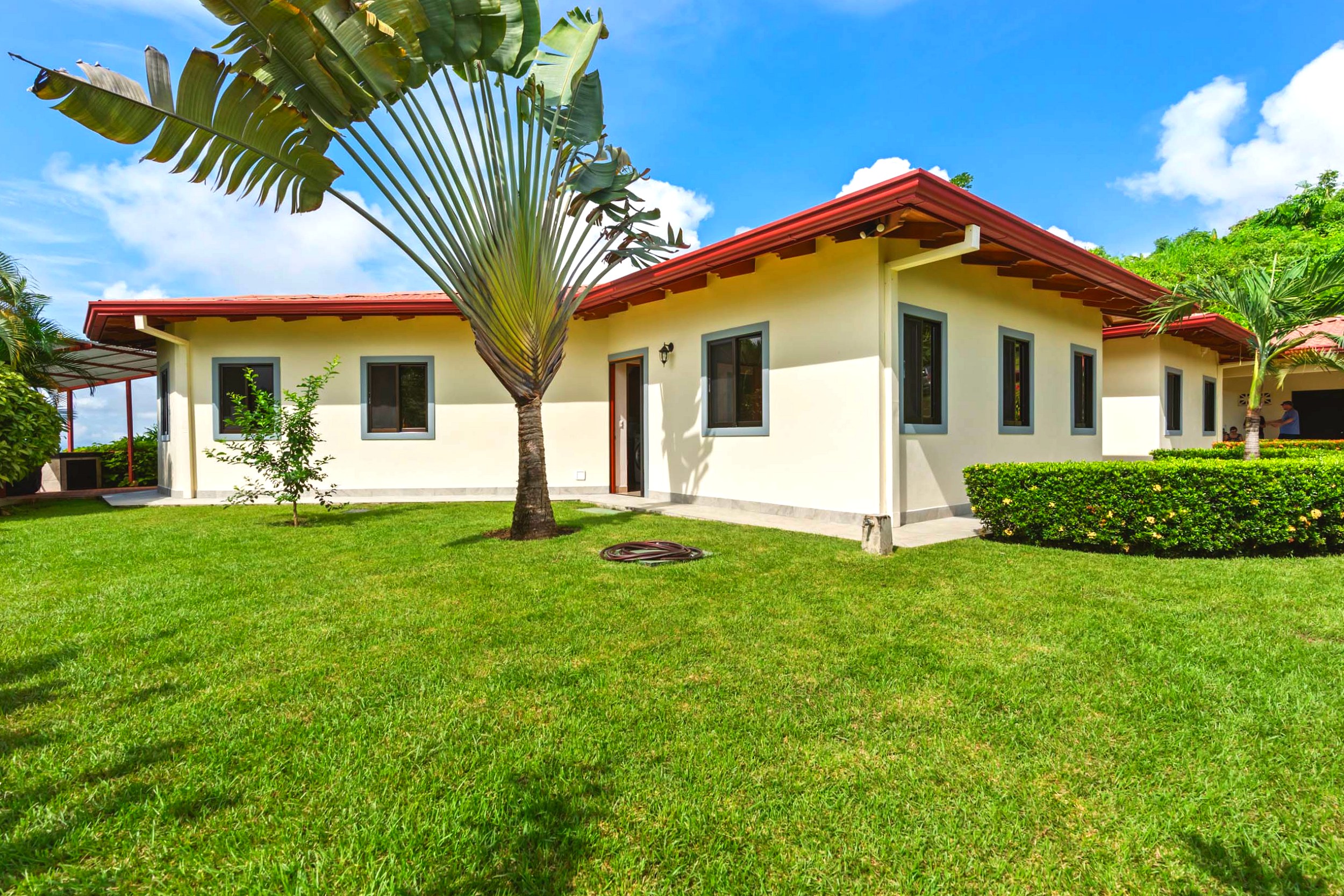 Luxurious Ocean View Home front exterior with green lawn and palm tree in Chontales, Costa Rica