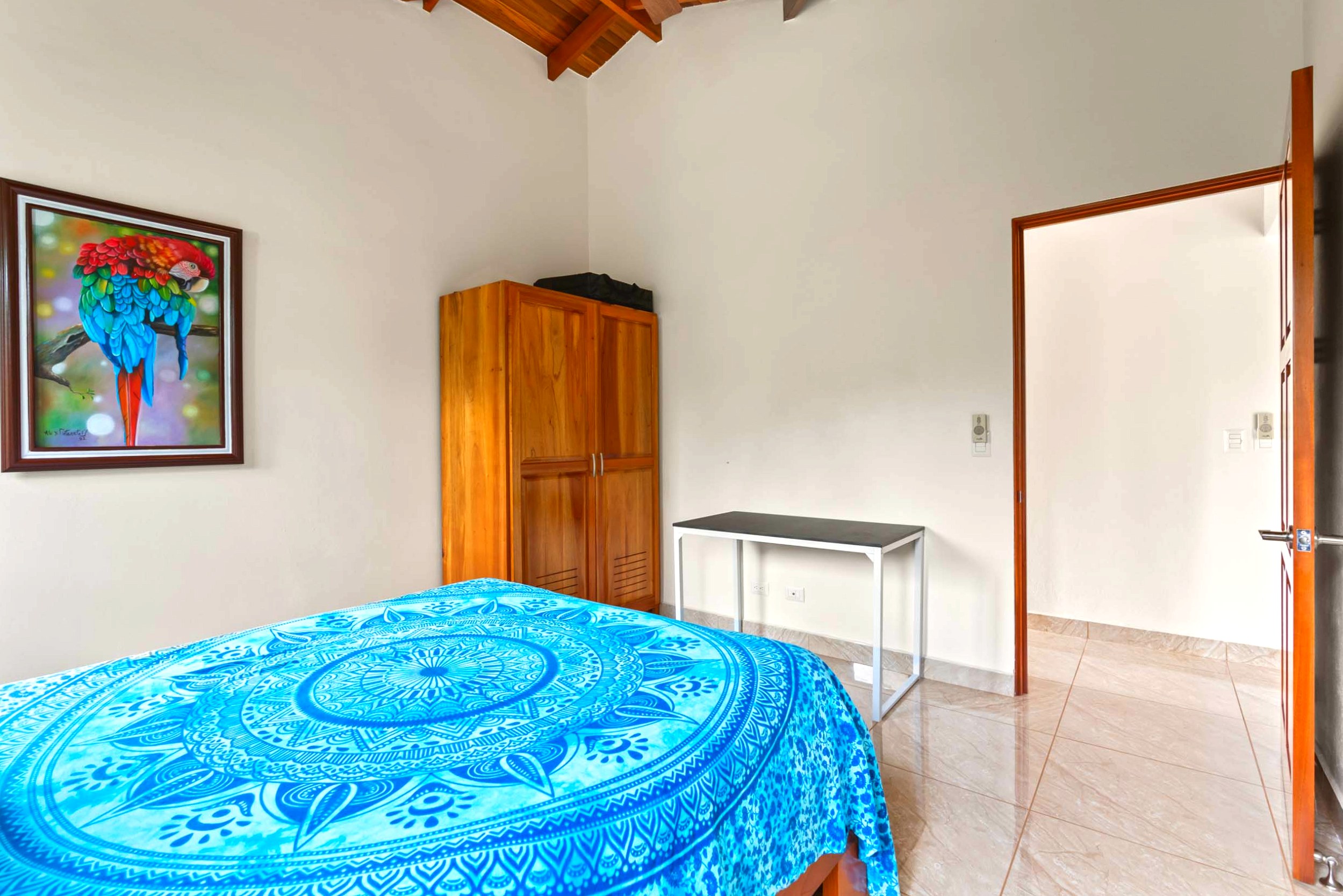 Luxurious Ocean View Home guest bedroom with blue bedspread in Chontales, Costa Rica.