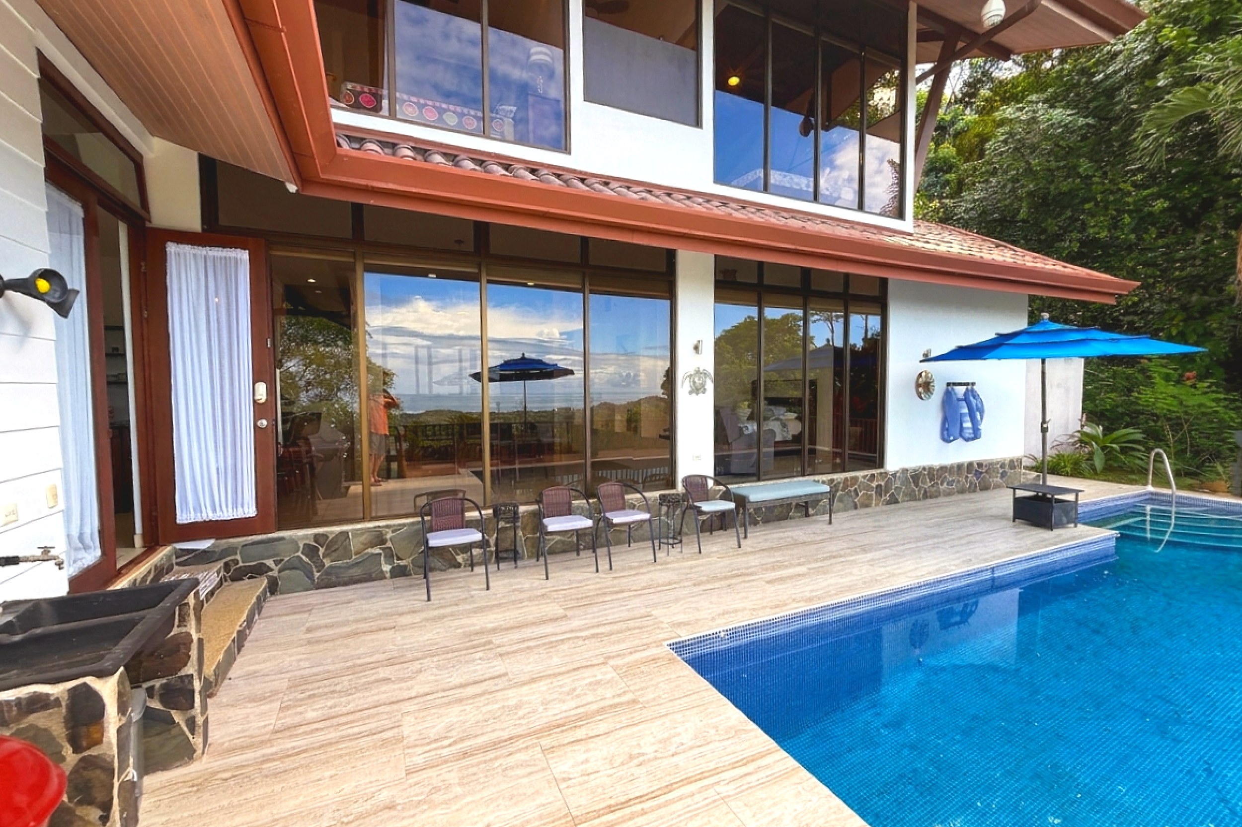 Pool & Sun Deck Ocean View Home pool deck with lounge chairs and umbrellas in Ojochal, Costa Rica