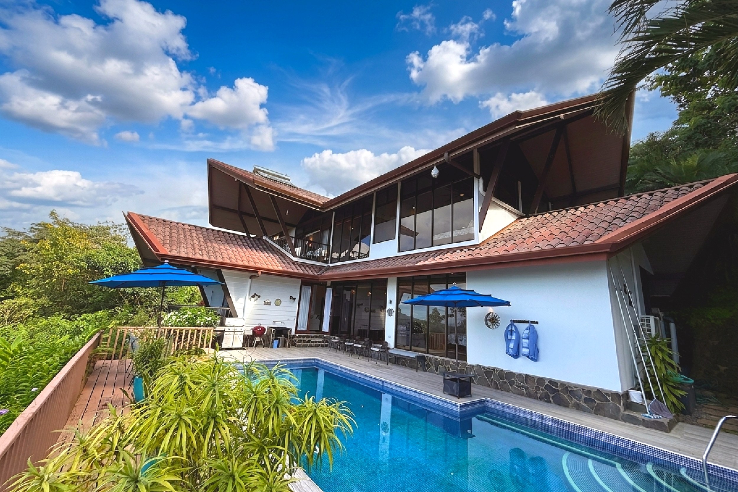 Pool & Sun Deck Panoramic Ocean View Home large pool with blue umbrellas and deck in Ojochal, Costa Rica