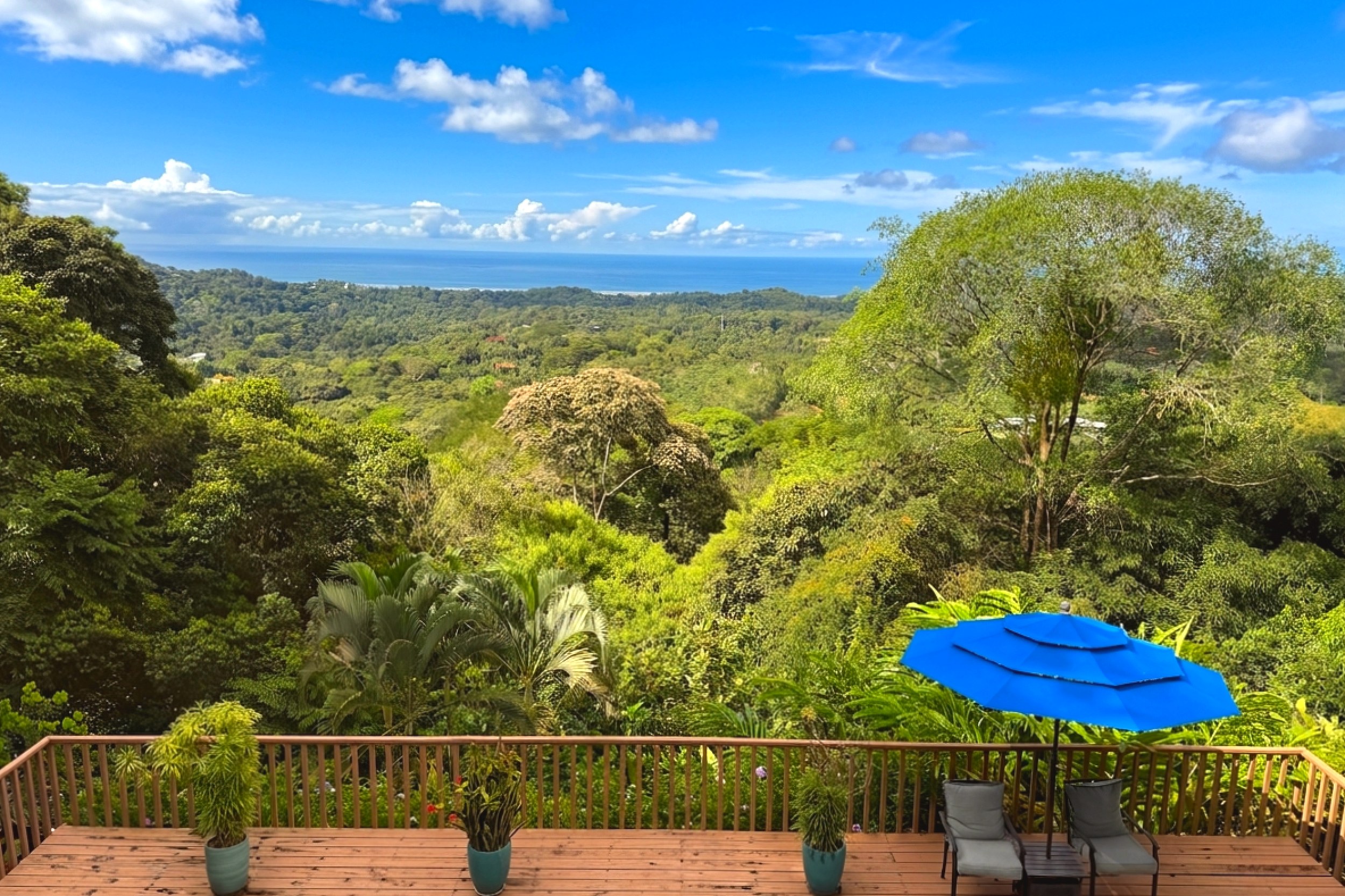 Terrace With Ocean Views Panoramic Ocean View Home wooden deck with blue umbrella and jungle-to-sea views in Ojochal, Costa Rica