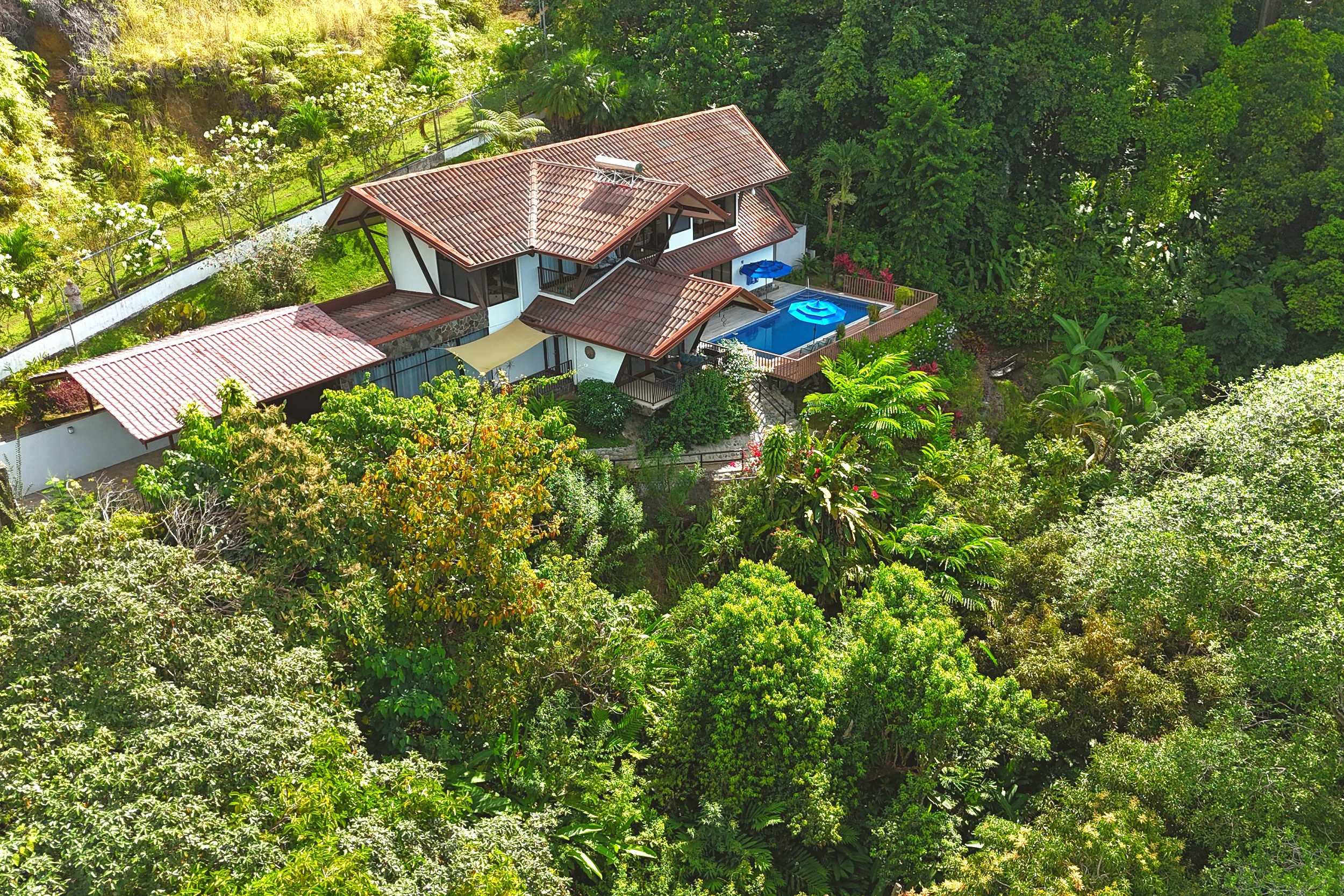 Aerial Jungle Estate View Panoramic Ocean View Home aerial view with pool amid lush jungle in Ojochal, Costa Rica