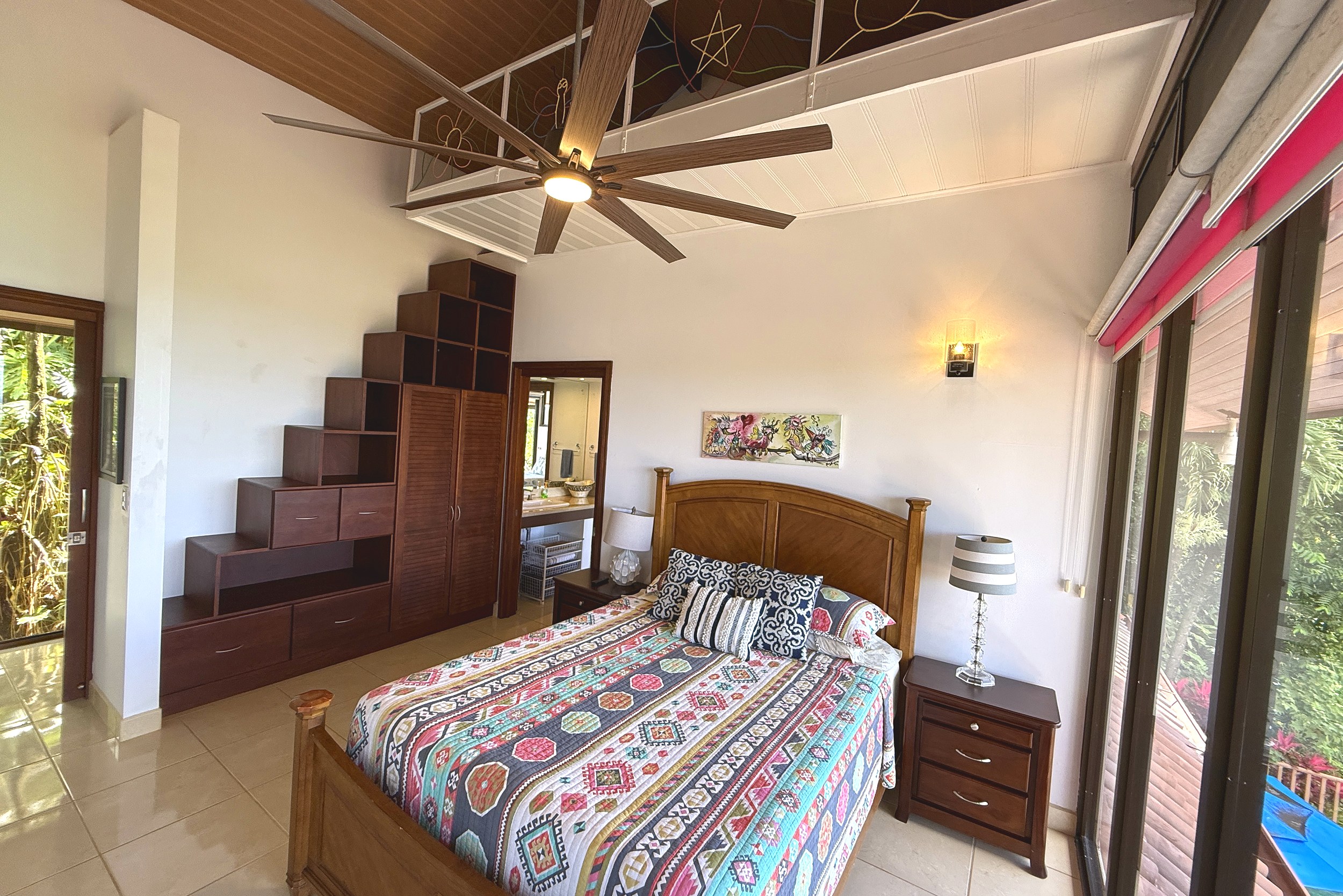 Cozy Guest Bedroom Ocean View Home guest bedroom with wooden staircase shelving and ceiling fan in Ojochal, Costa Rica