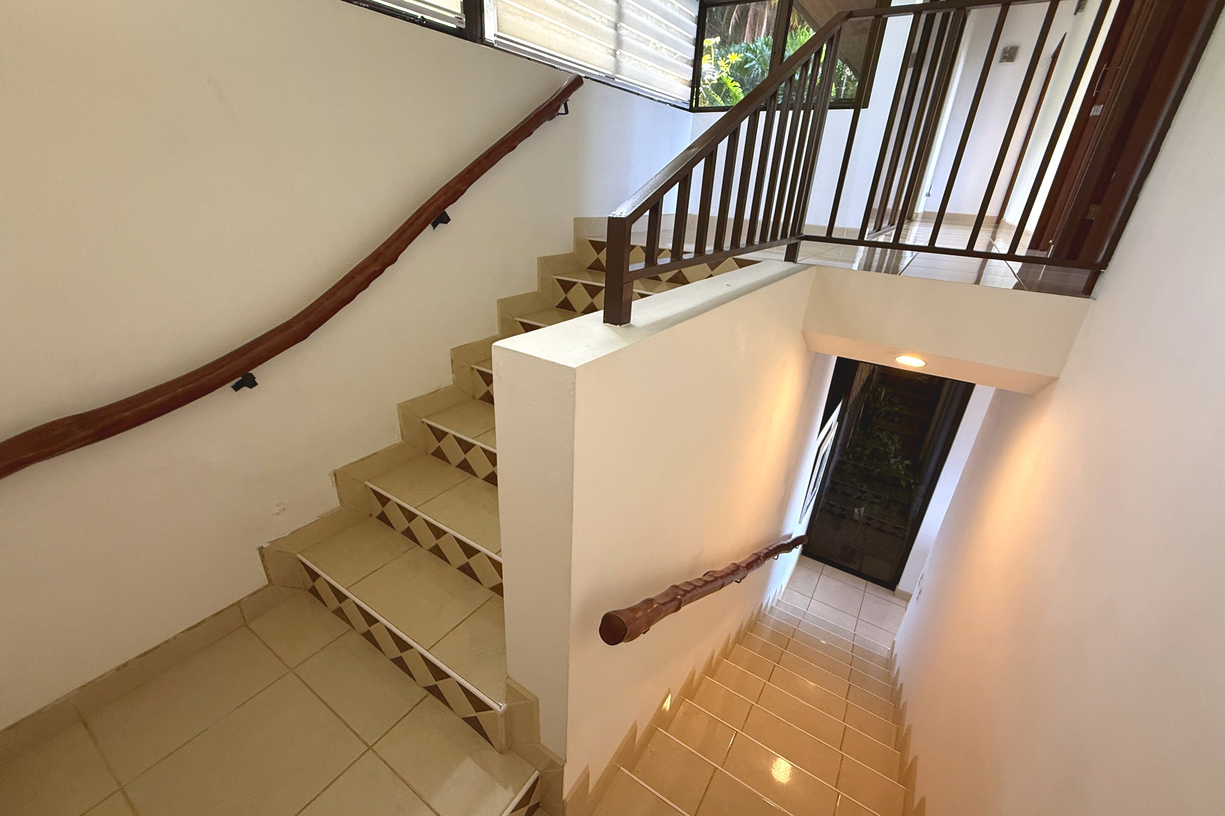 Tiled Staircase Landing Ocean View Home tiled staircase with wood handrails in Ojochal, Costa Rica