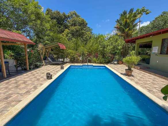 Jungle Hotel sparkling pool surrounded by lush tropical greenery in Ojochal, Costa Rica.