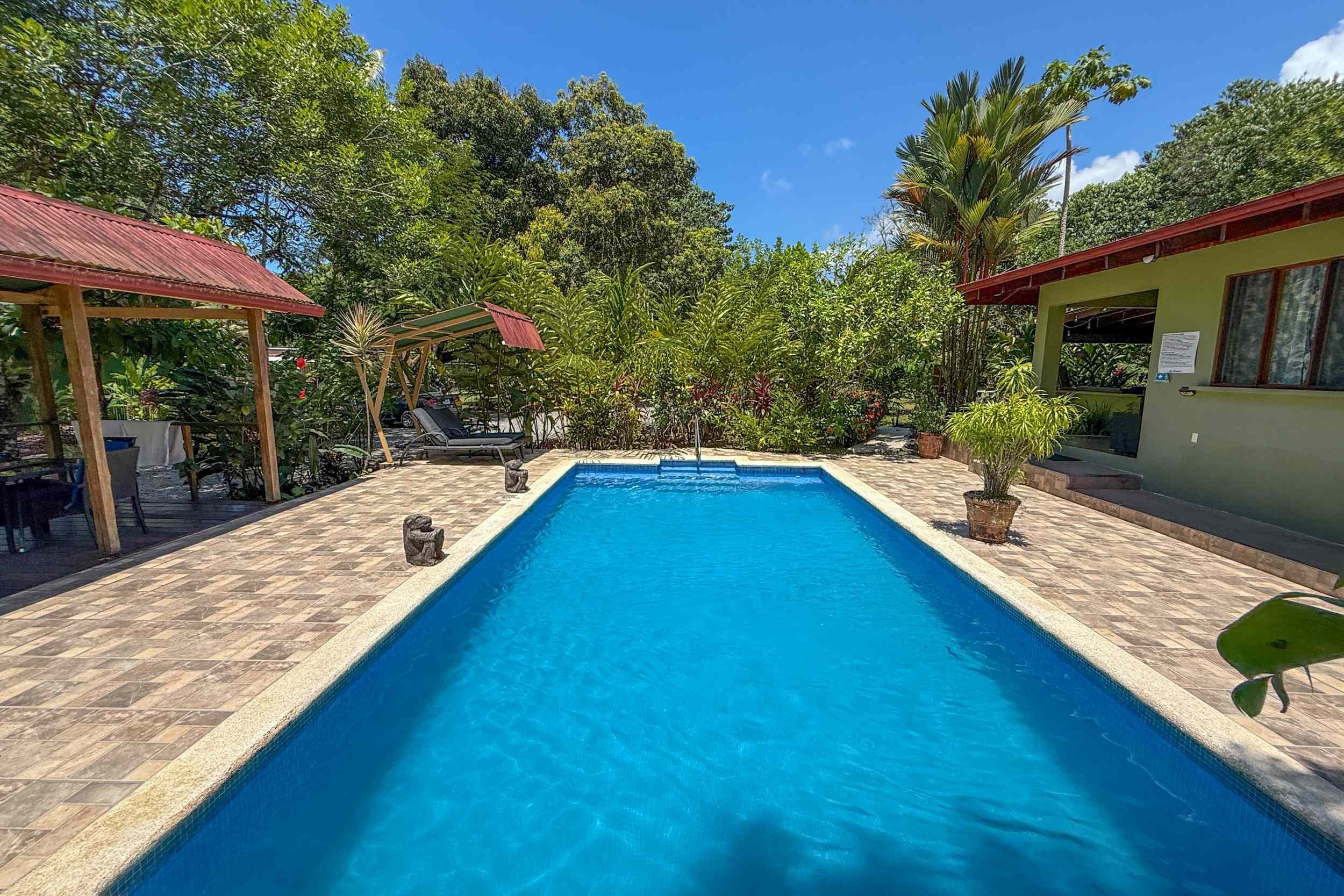 Jungle Hotel sparkling pool surrounded by lush tropical greenery in Ojochal, Costa Rica.