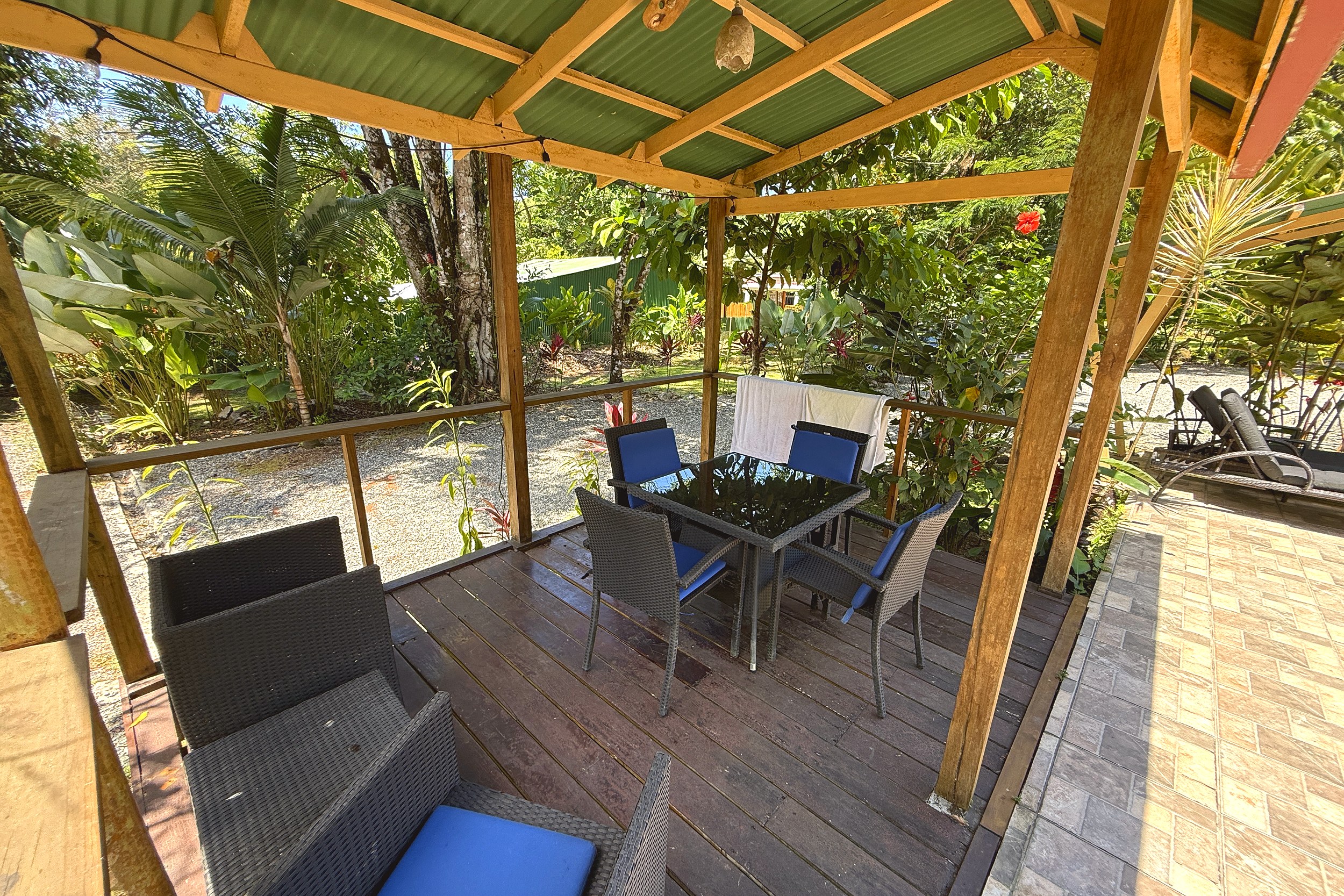 Covered Deck & Dining Area Jungle Hotel covered wooden deck with dining table and lounge seating in Ojochal, Costa Rica