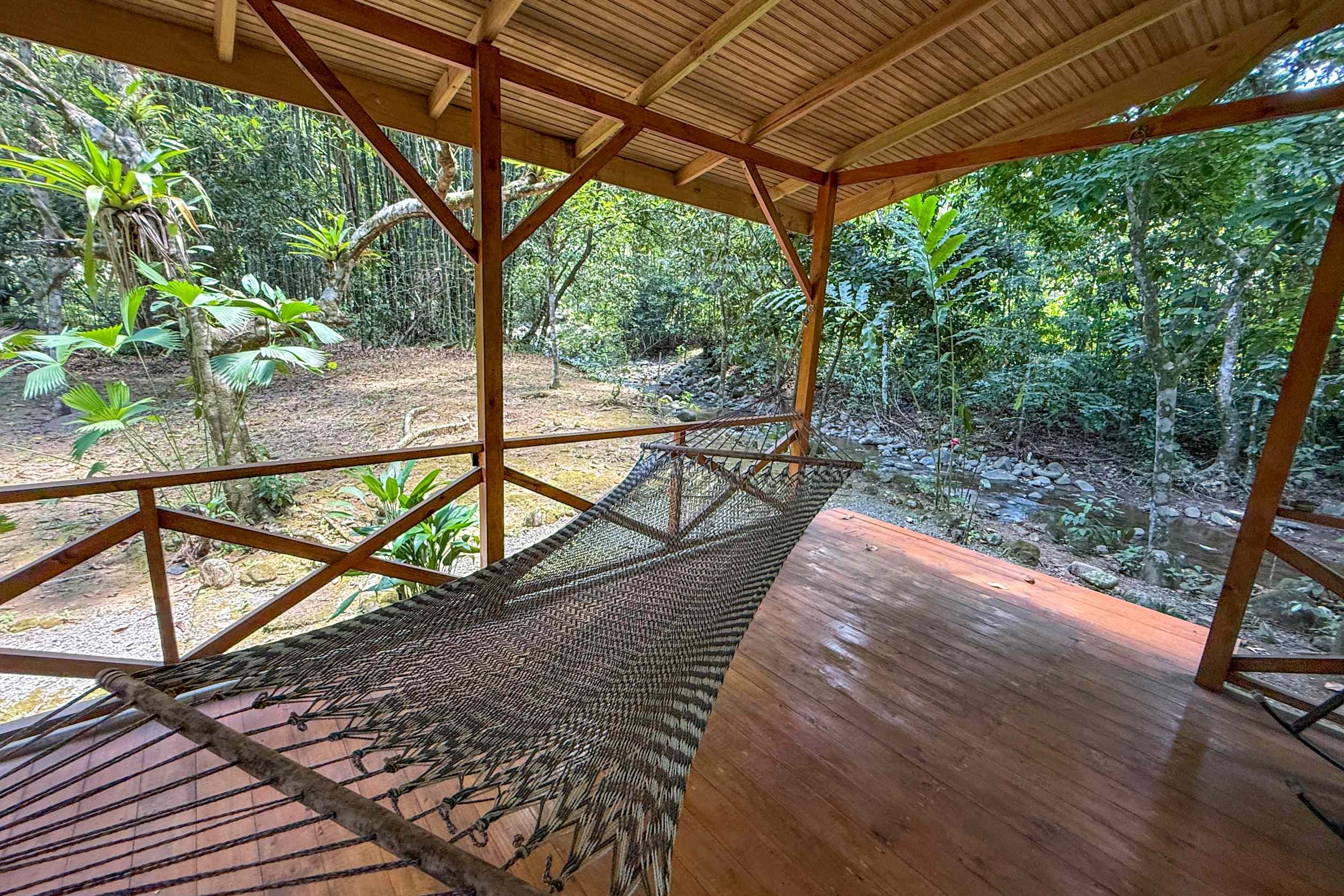 Riverside Terrace & Hammock Jungle Hotel wooden terrace with hammock overlooking river in Ojochal, Costa Rica