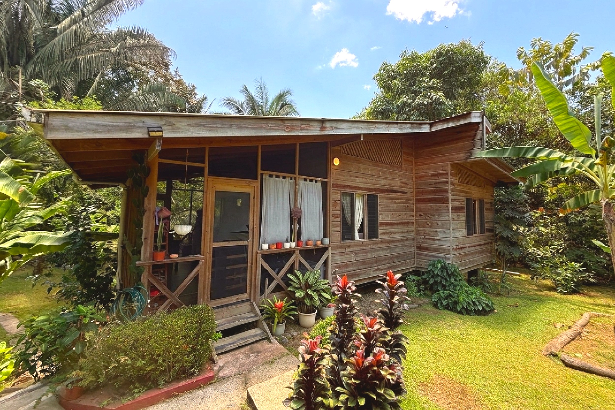 Wooden Cabin Exterior Jungle Hotel wooden cabin with covered porch and tropical garden in Ojochal, Costa Rica