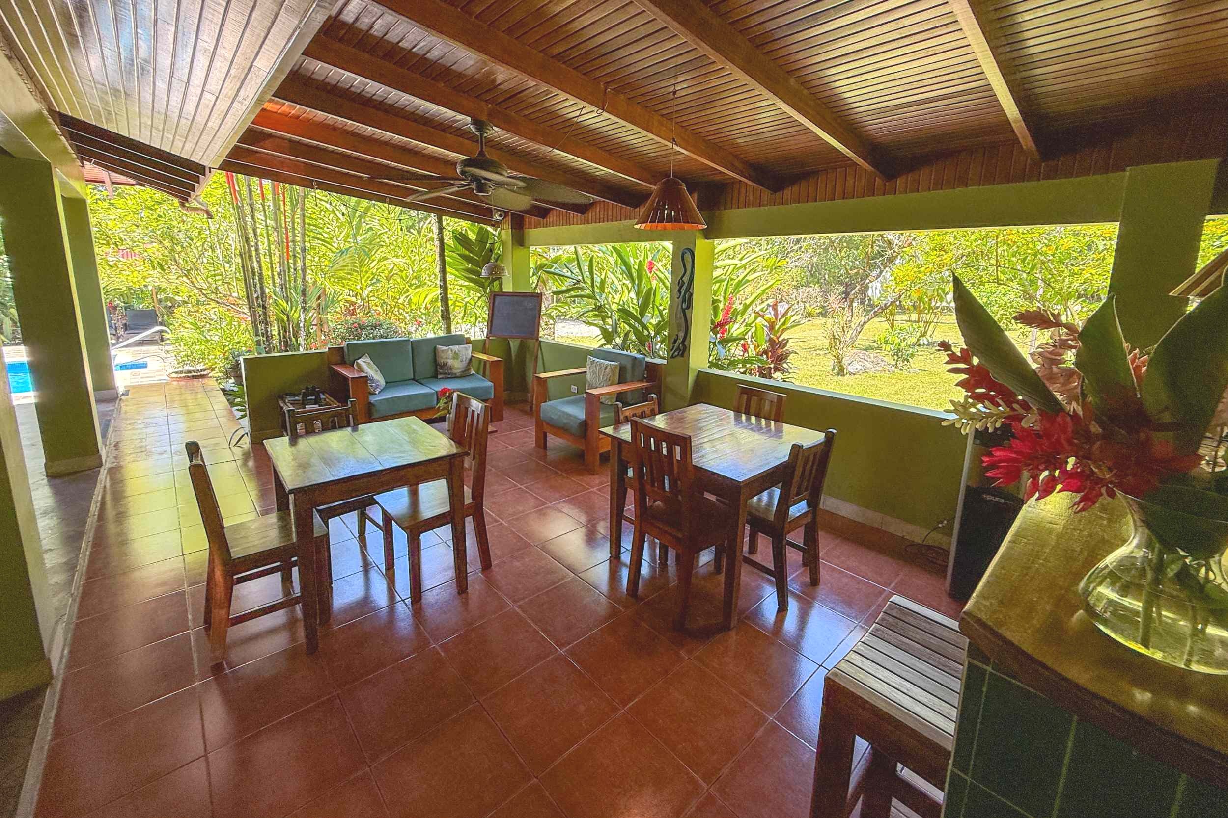 Open-Air Dining Terrace Jungle Hotel covered dining area with wooden tables and pool view in Ojochal, Costa Rica