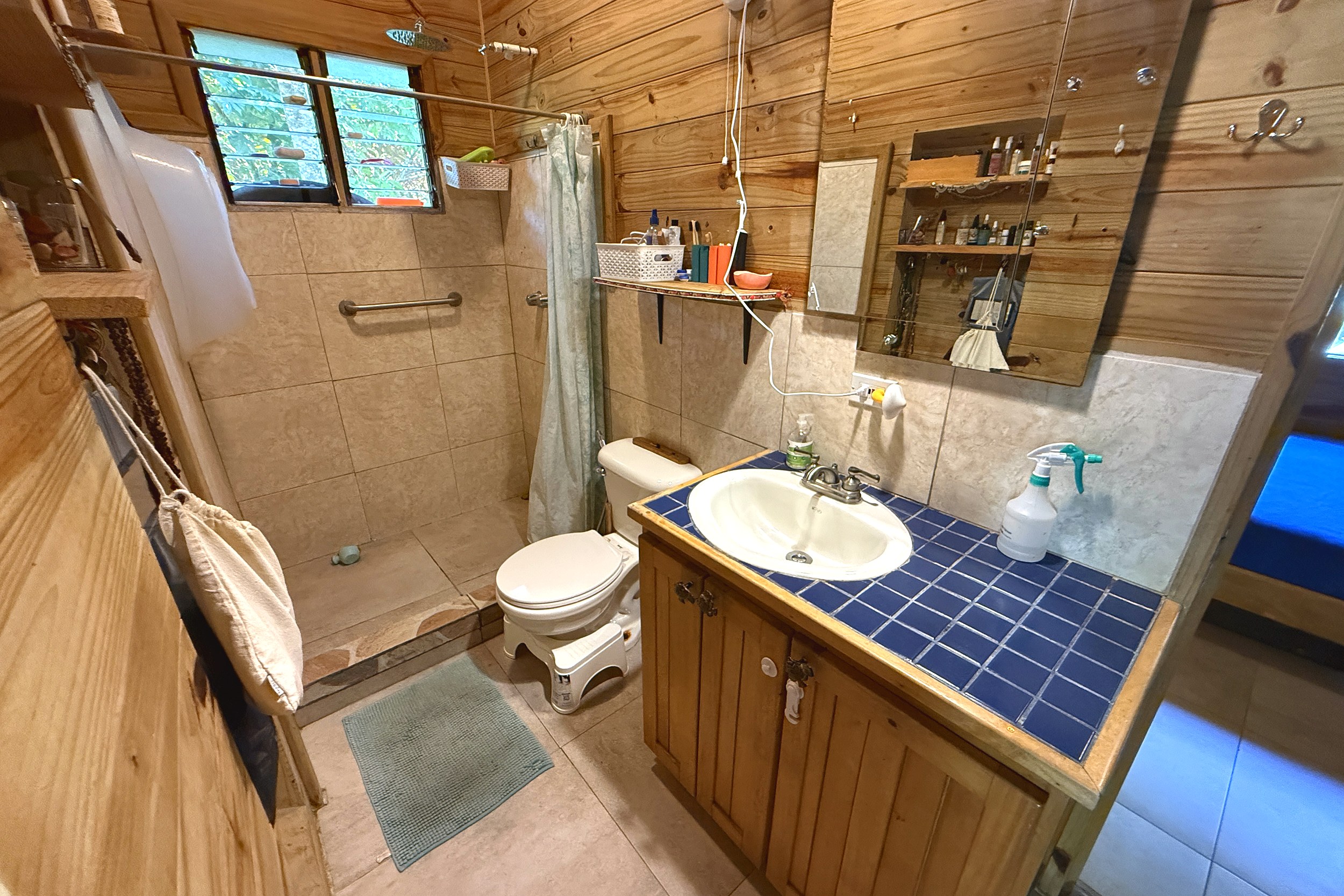 Rustic Master Bathroom Jungle Hotel wood-paneled bathroom with walk-in shower and blue tile vanity in Ojochal, Costa Rica