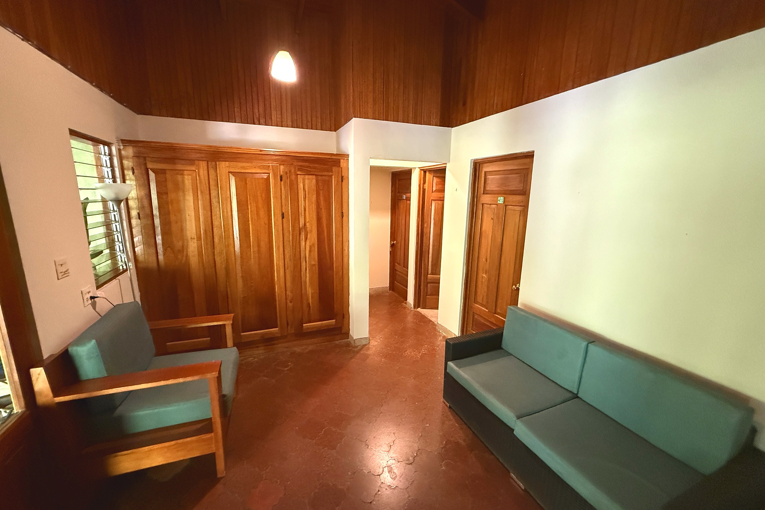 Cozy Lounge Seating Area Jungle Hotel lounge area with wooden built-ins and teal sofas in Ojochal, Costa Rica