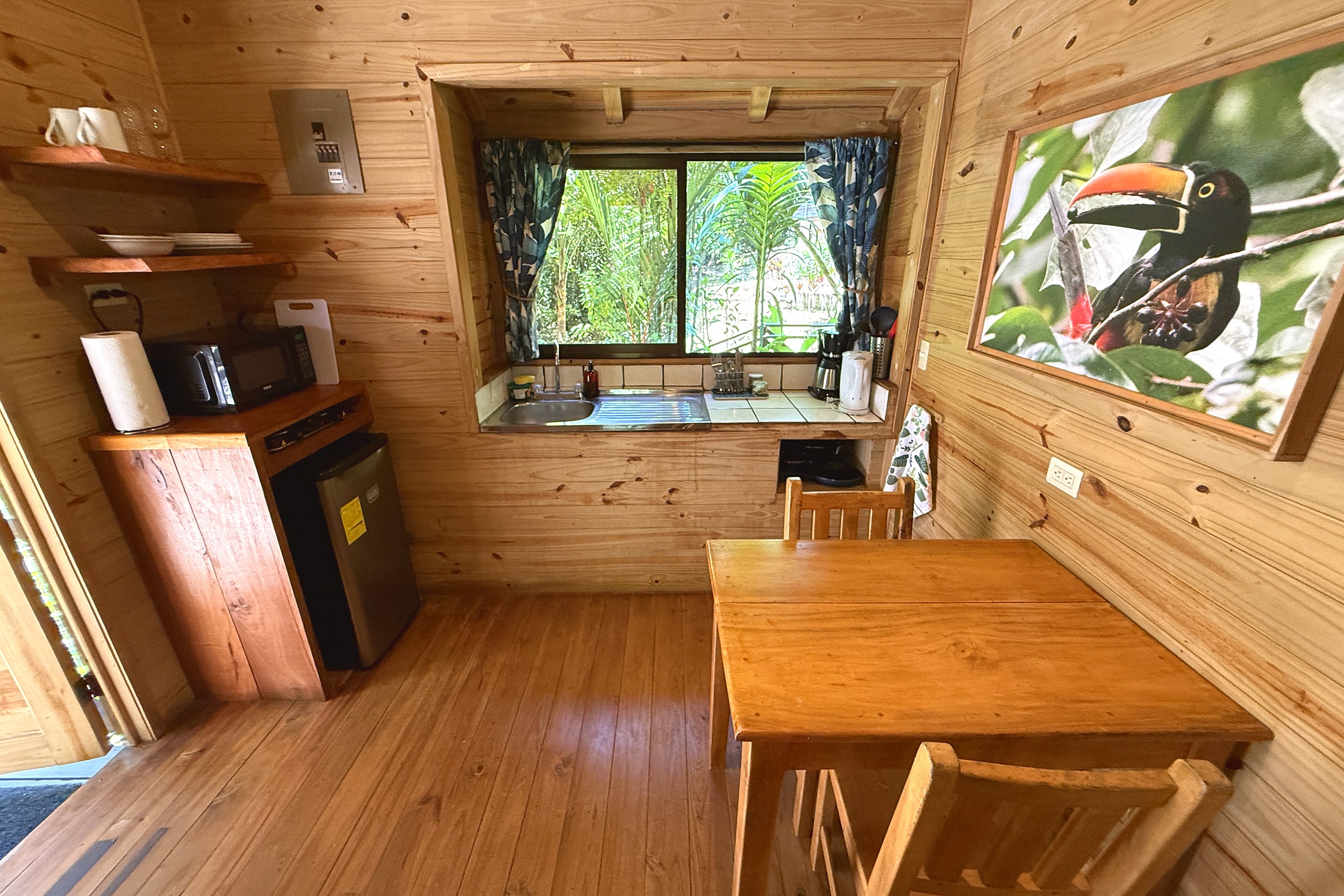 Cozy Guesthouse Dining Nook Jungle Hotel wooden kitchenette and dining table with toucan art in Ojochal, Costa Rica
