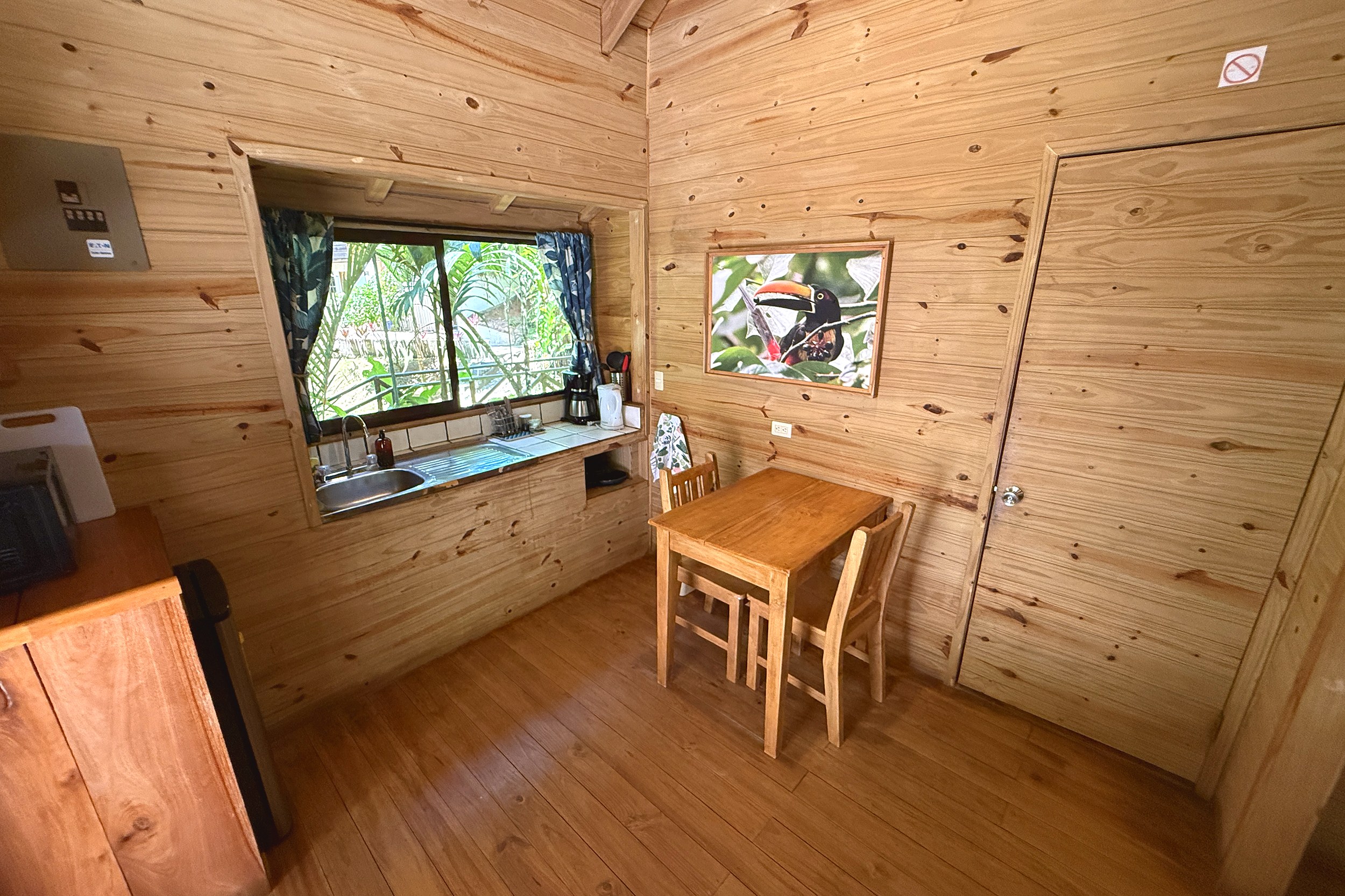 Cozy Wood-Paneled Dining Nook Jungle Hotel wooden dining nook with toucan art in Ojochal, Costa Rica
