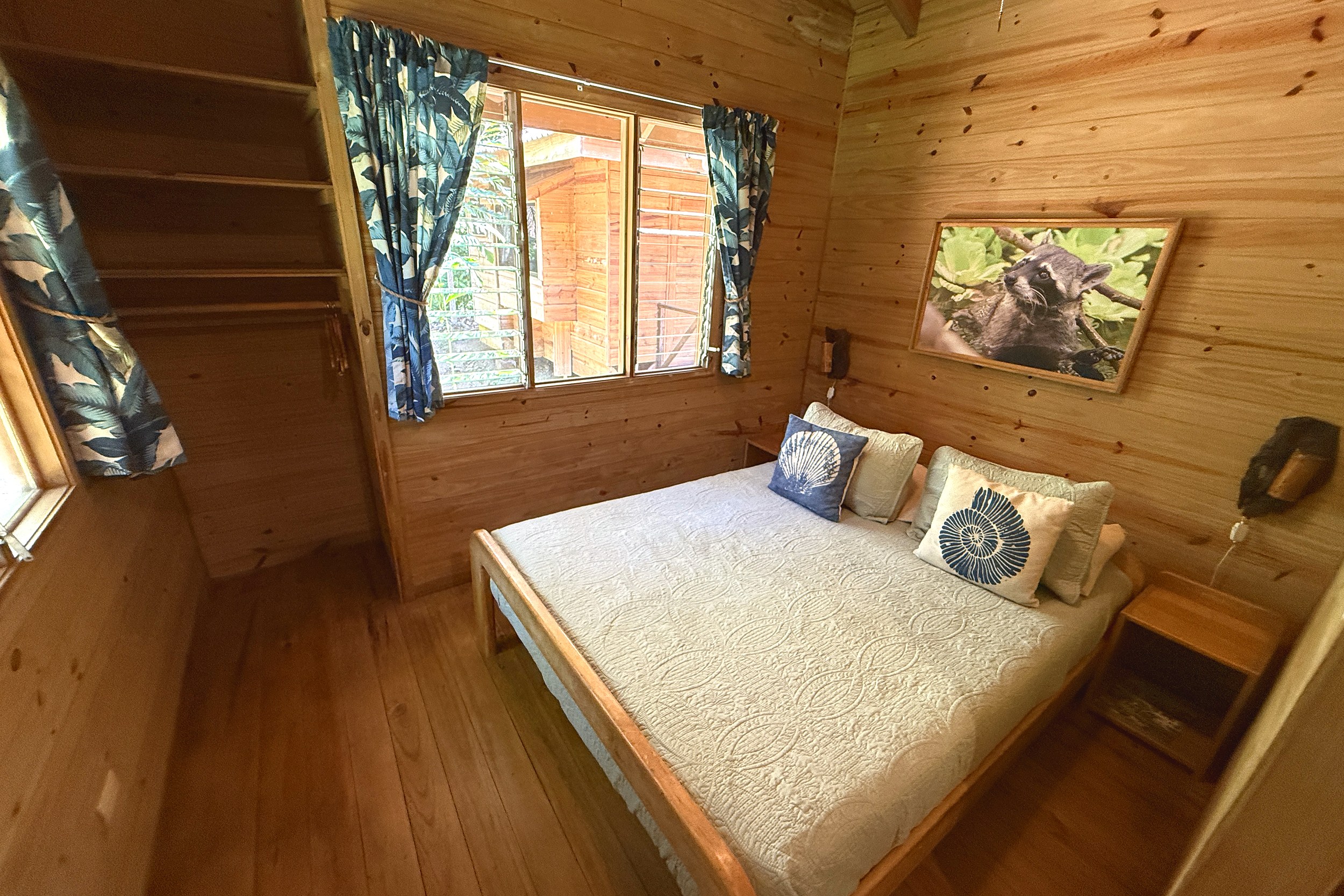 Cozy Wood-Paneled Guest Bedroom Jungle Hotel Guesthouse wood-paneled bedroom with queen bed in Ojochal, Costa Rica