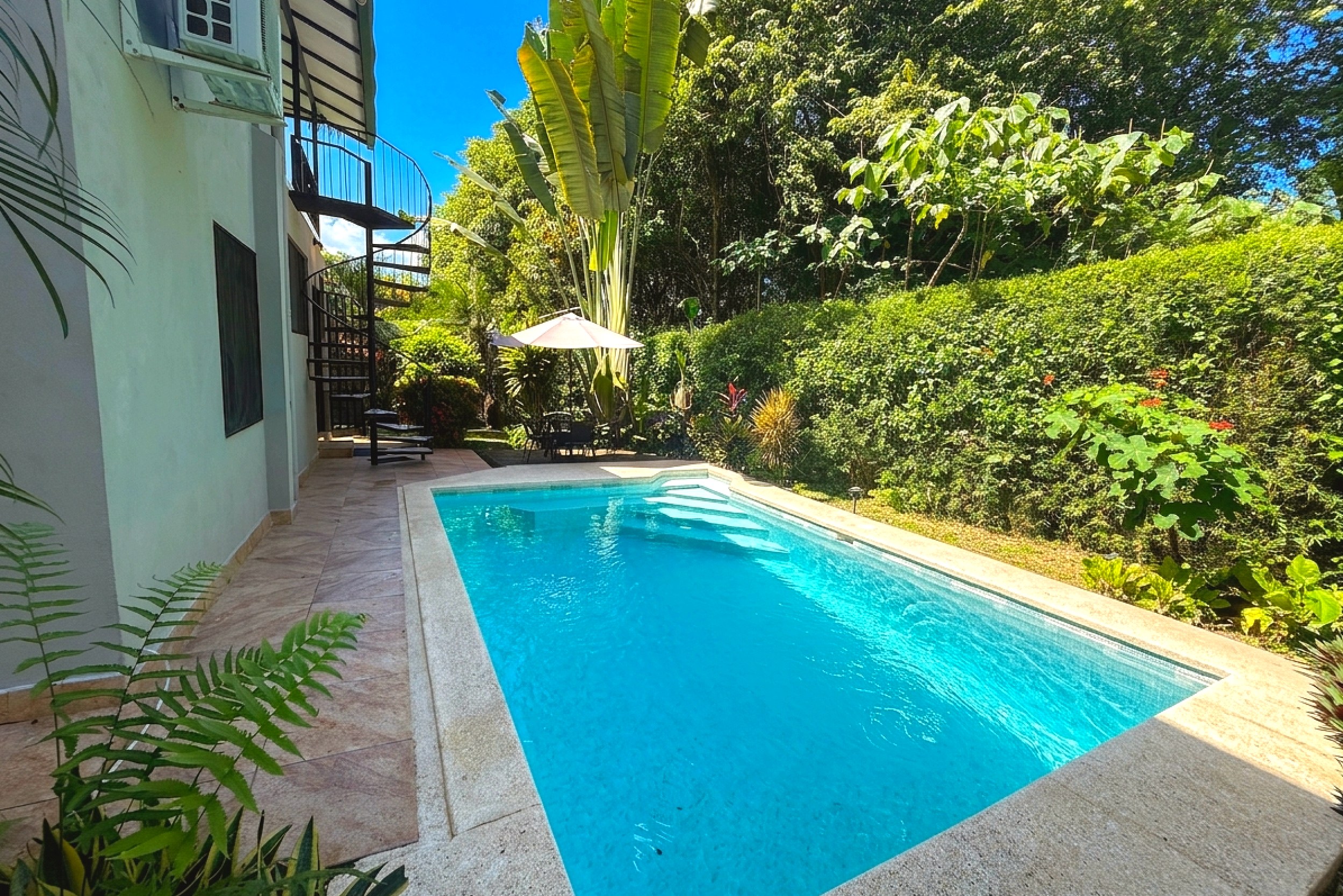 Private Pool & Jungle View Jungle Sanctuary private pool with spiral staircase and lush greenery in Ojochal, Costa Rica.