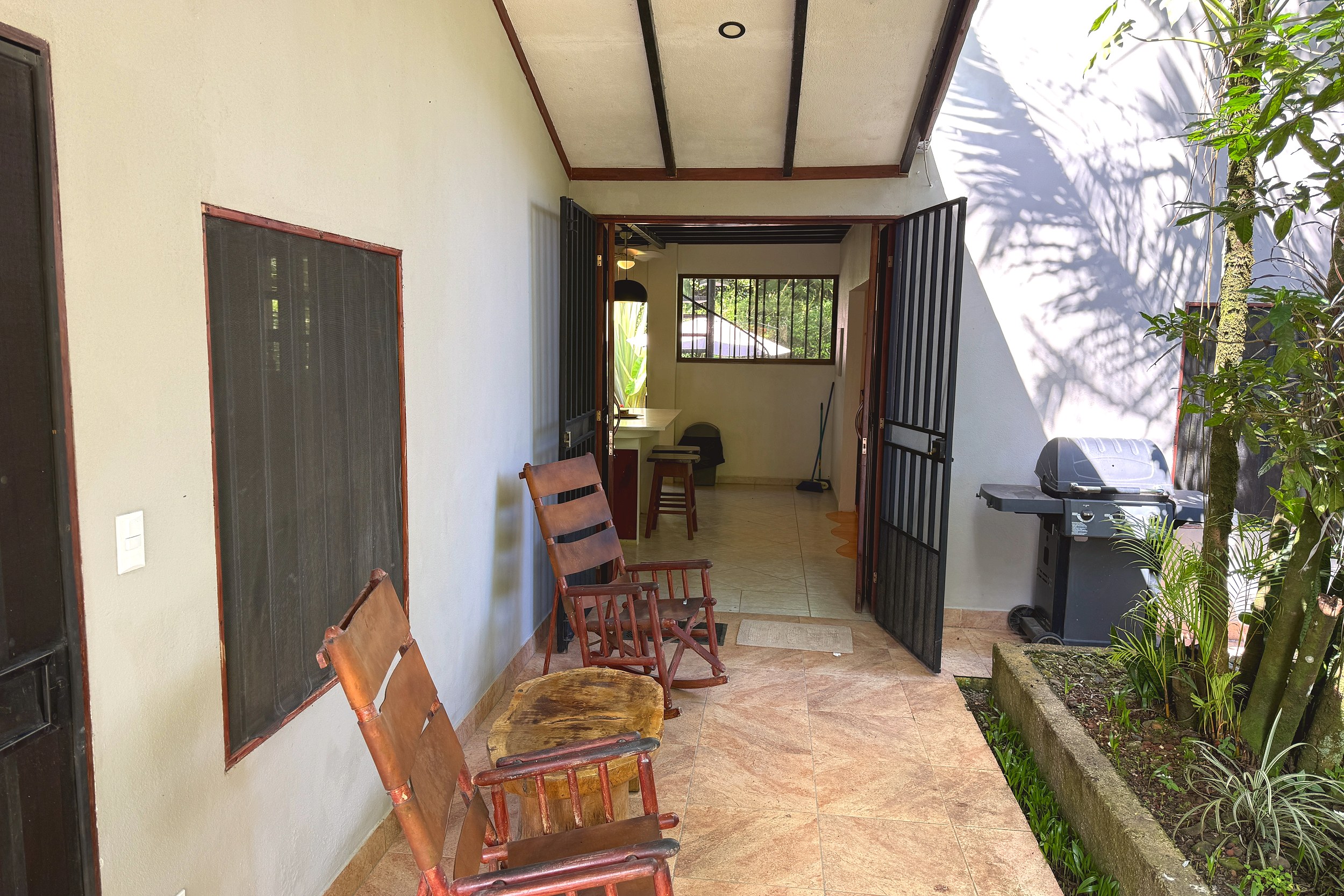 Covered Terrace Seating Jungle Sanctuary covered tiled terrace with wooden rocking chairs in Ojochal, Costa Rica