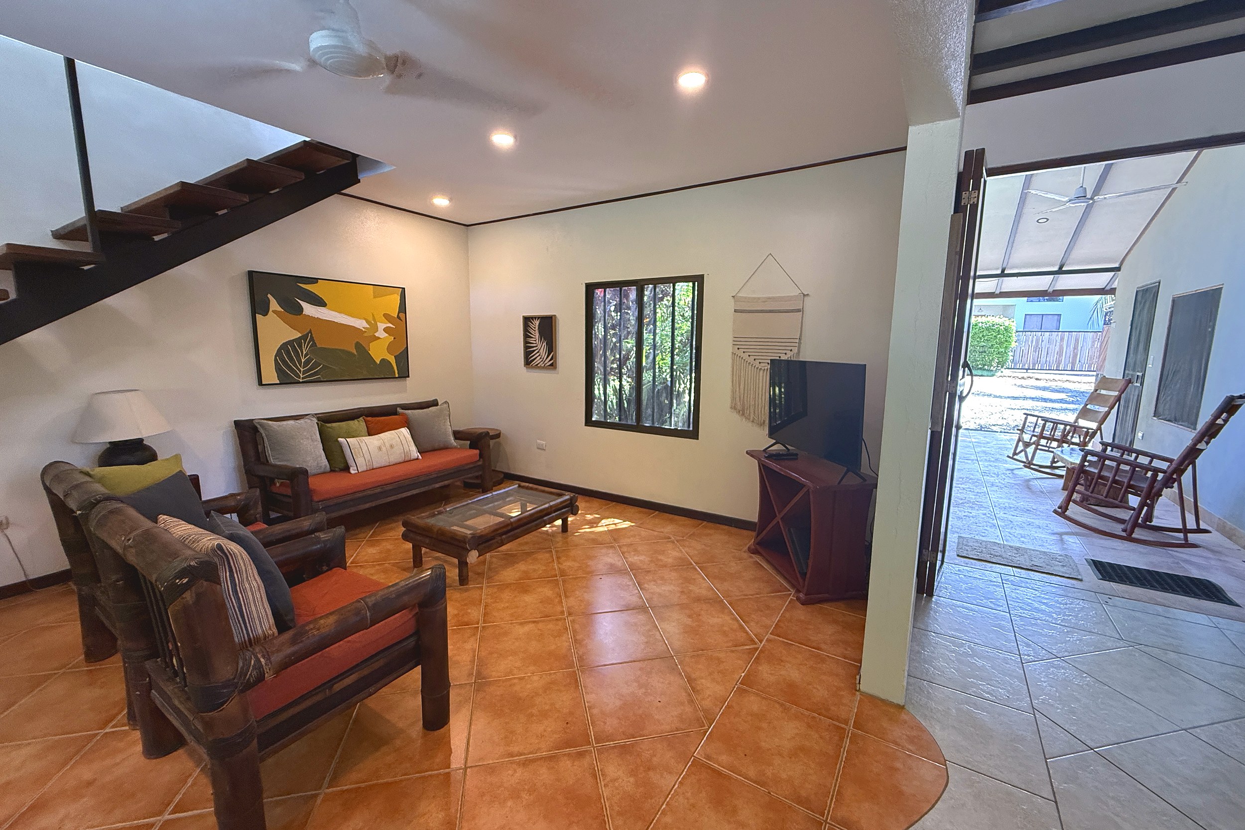 Cozy Living Room Serene Jungle Sanctuary living room with wooden furniture and staircase in Ojochal, Costa Rica