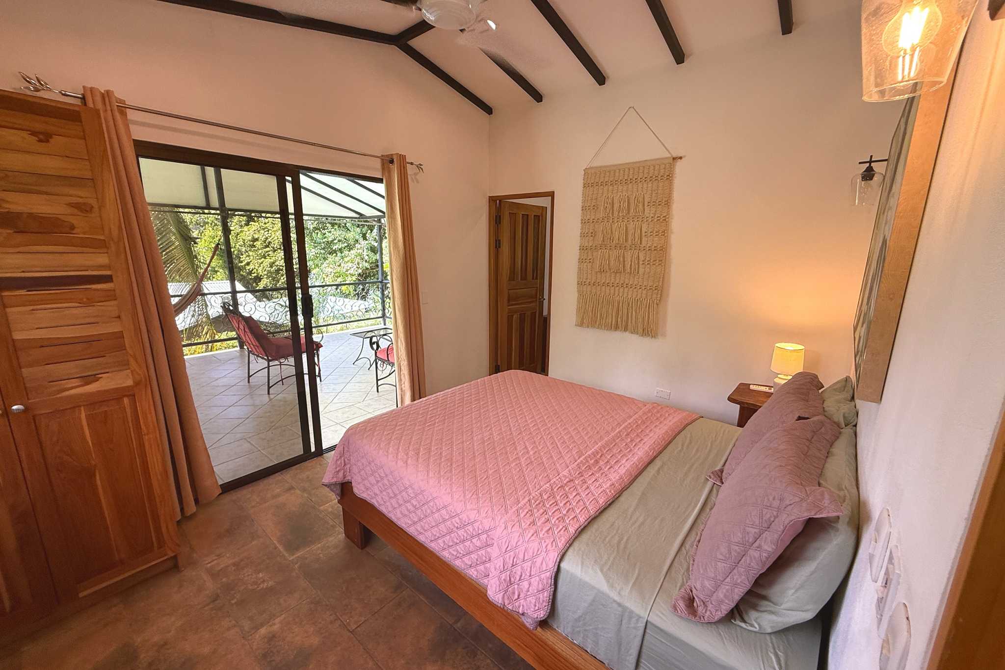 Master Bedroom with Patio Access Jungle Sanctuary bedroom with pink quilt bed and patio access in Ojochal, Costa Rica