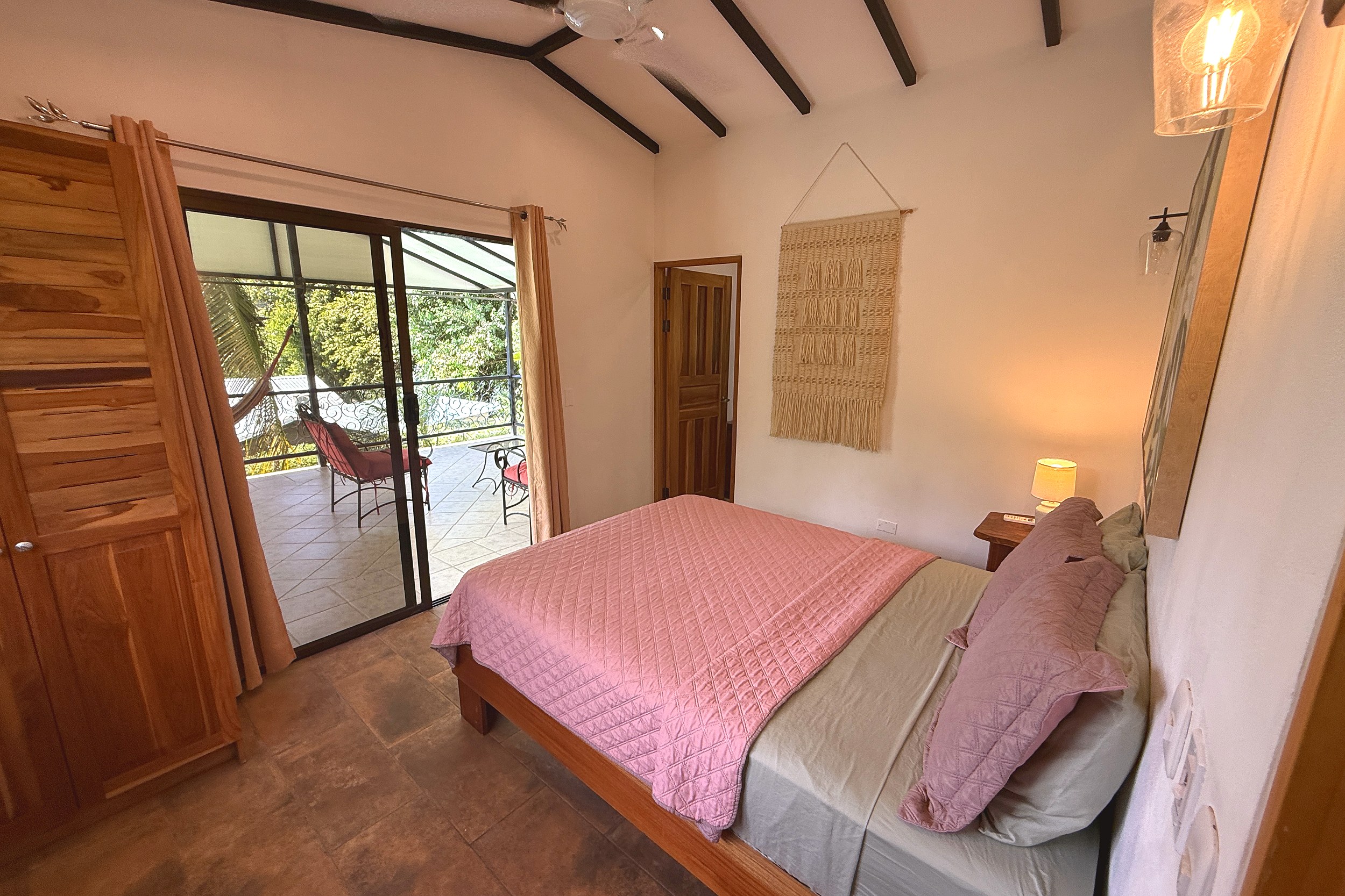 Master Bedroom with Patio Access Jungle Sanctuary bedroom with pink quilt bed and patio access in Ojochal, Costa Rica