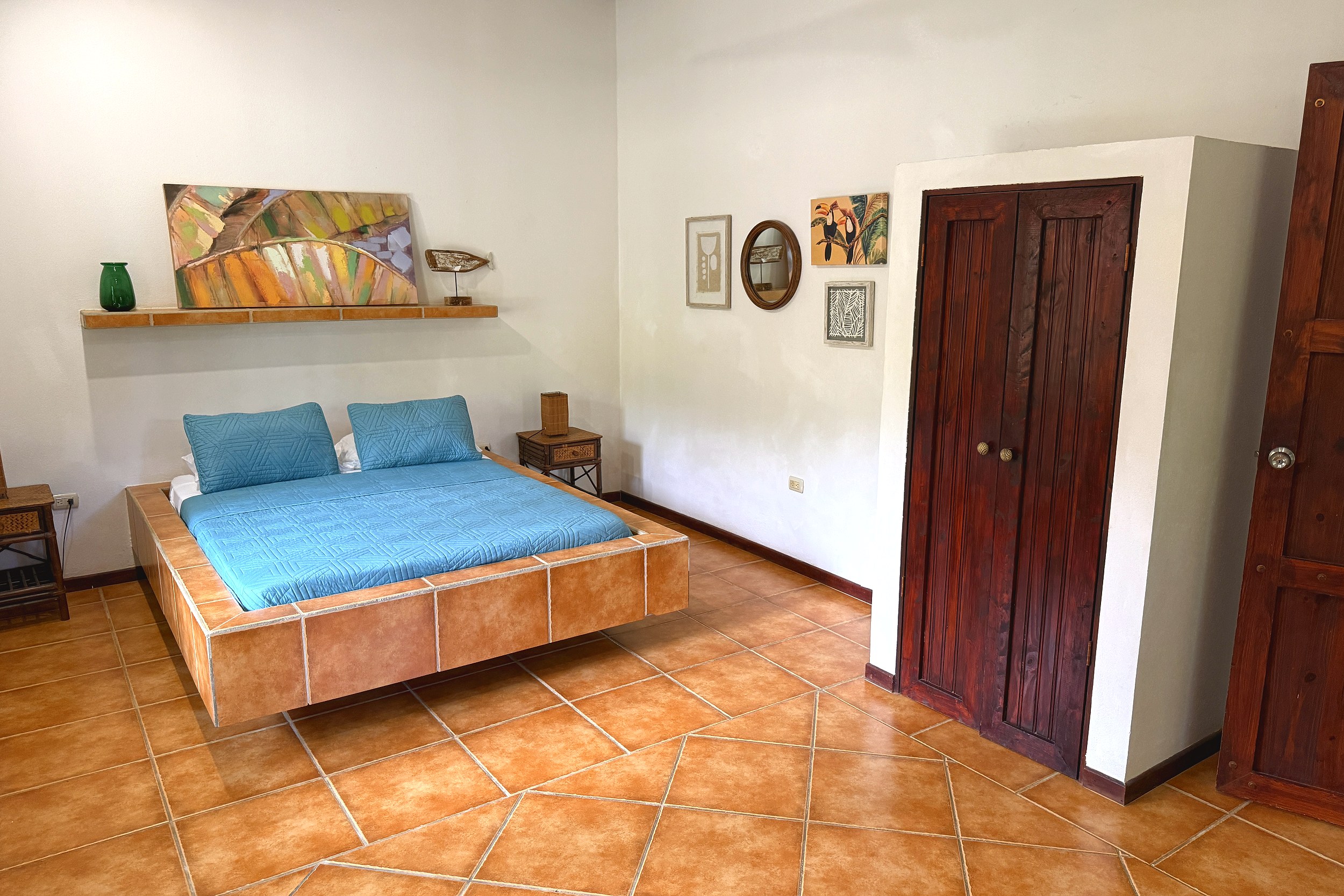 Main Guest Bedroom Jungle Sanctuary bedroom with tiled platform bed and wooden armoire in Ojochal, Costa Rica