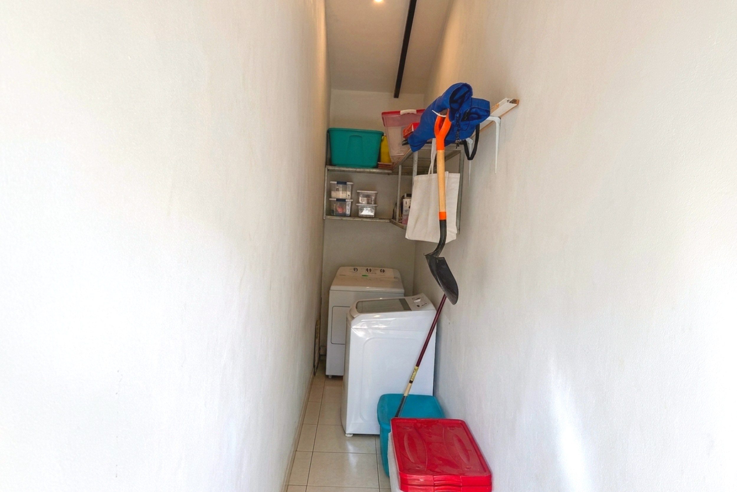 Utility & Laundry Area Jungle Sanctuary narrow laundry hallway with stacked washer dryer in Ojochal, Costa Rica