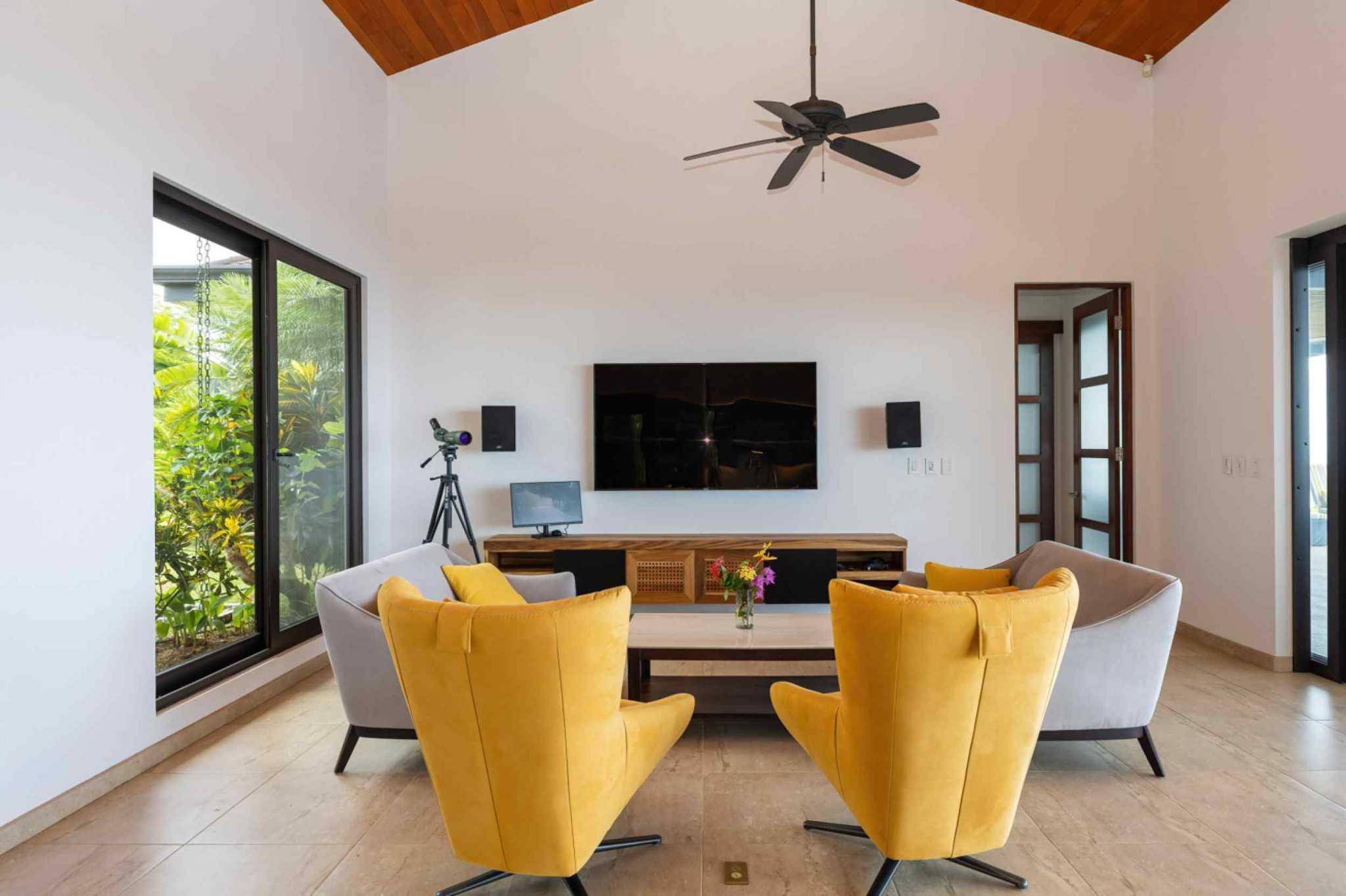 72497-6 Luxury Home living room with yellow wingback chairs, gray armchairs, TV console and garden views in Ojochal, Costa Rica