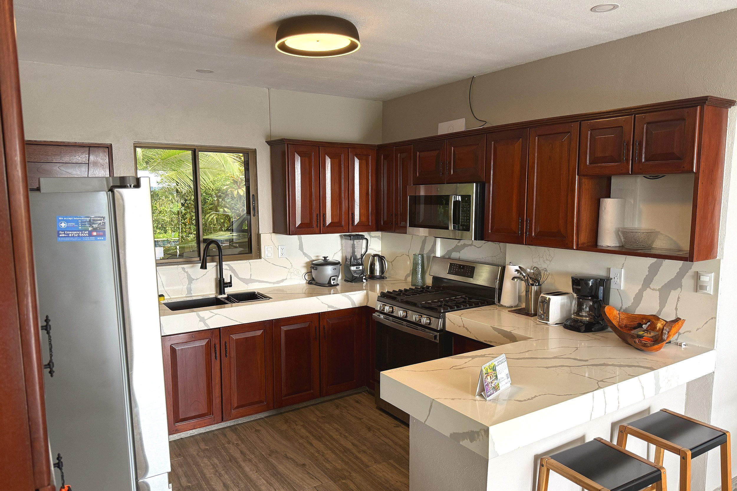 Kitchen & Breakfast Bar Kitchen Home dark wood cabinets, stainless appliances, marble countertops in Costa Rica