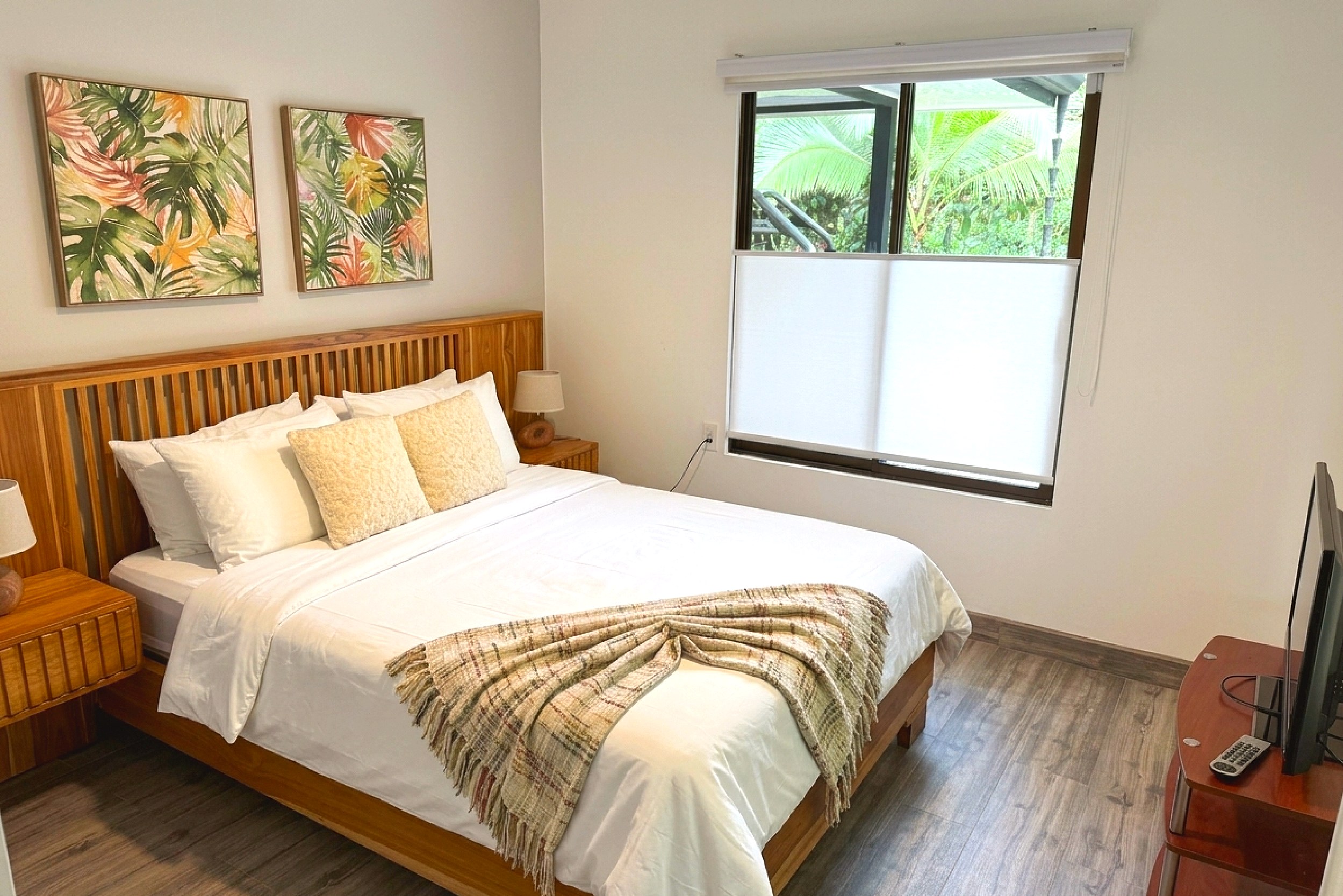 Cozy Tropical Guest Bedroom Guest Bedroom wooden bed with tropical wall art in Costa Rica