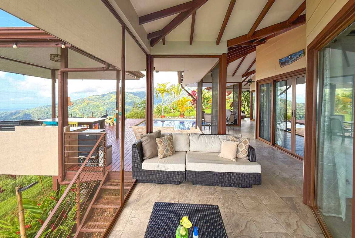 Covered terrace and dining set overlook a private pool and mountain views in Toucan Valley, Costa Rica.